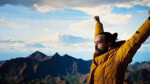 Escalador celebrando en la cima de una montaña